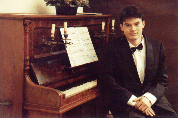 Alin Gherman in formal attire next to an antique piano — Brussels, 1999