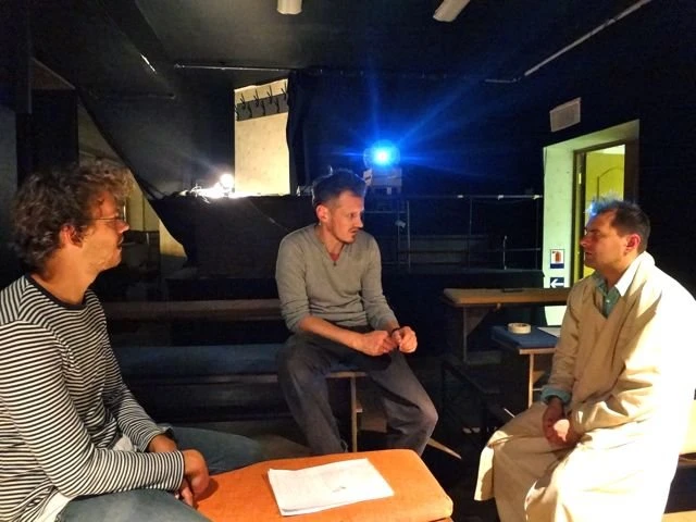 Three people discussion dark stage